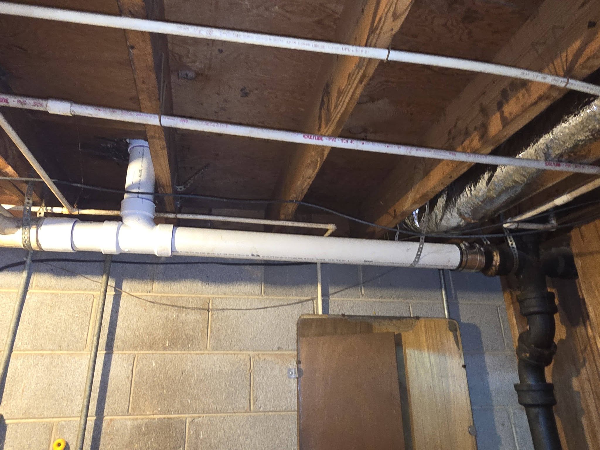New PVC main drain line tied into existing cast iron in a crawlspace